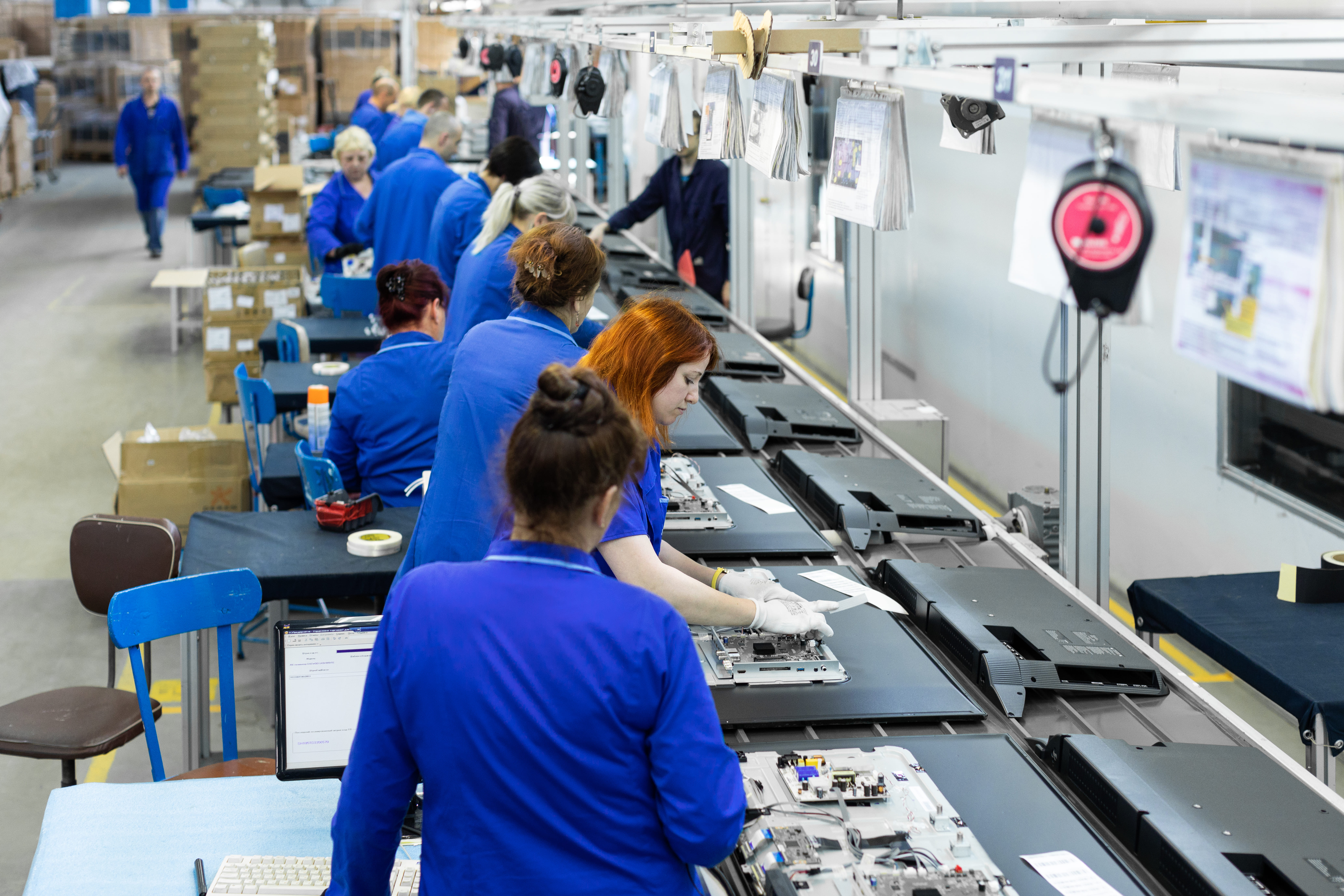 Electronics operators working along a production line.