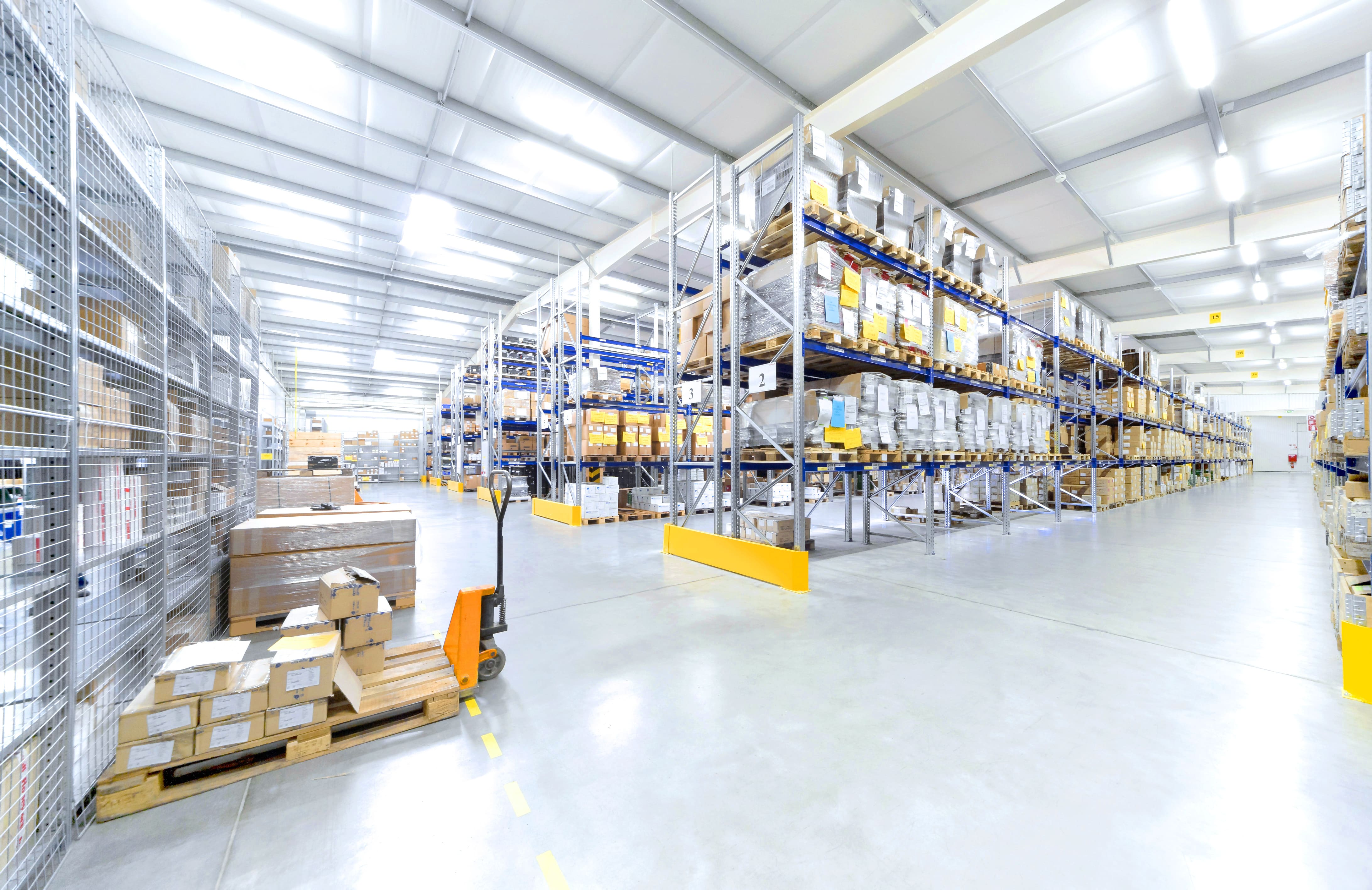 Warehouse with pallet racking, labelled stock and inbound goods.